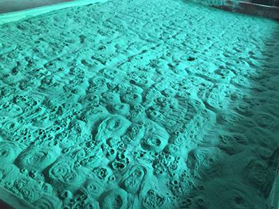Green polyethylene powder boiling in a large pool in workshop