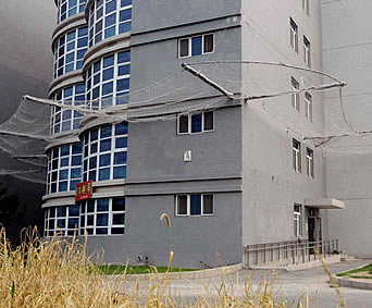 Stainless steel safety net mounted below a high building to protect below pedestrians.