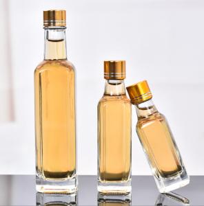 China Glass Olive Oil Bottle 100ml 250ml 500ml Round Clear Cooking Oil Bottle with Cap wholesale