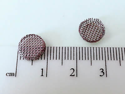 Two small bowl shaped filters are measured by a ruler and their diameters are about 9 mm.